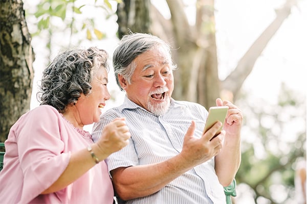 ymt blog how to save on your phone bill when traveling older couple laughing on smartphone