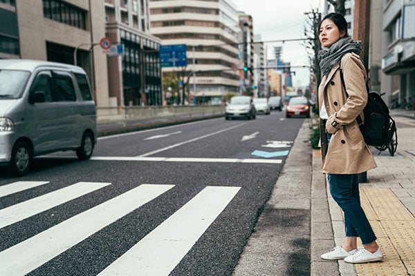ymt-blog-japanese-customs-dos-and-donts-for-visiting-japan-woman-waiting-at-crosswalk