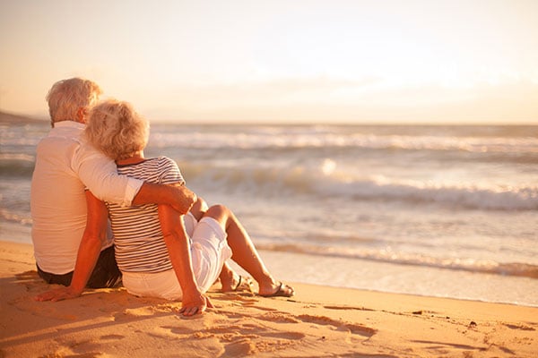 Couple-Relaxing-on-Beach_IS-ymt-blog-benefits-of-taking-more-vacations-couple-relaxing-on-beach