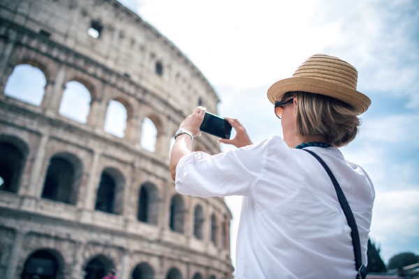 WOMAN TAKING A PICTURE OF THE COLISEUM IN ROME