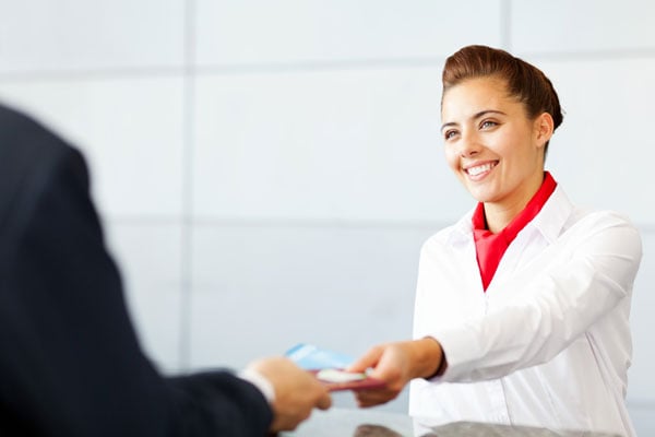 airport check-in agent handing person ticket
