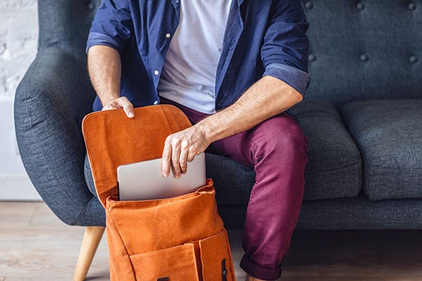 ymt-blog-tips-for-staying-cyber-safe-while-traveling-man-packing-laptop